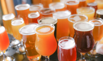 A table full of a variety of craft beers in their respective glassware.