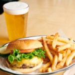 a draft beer, burger and fries