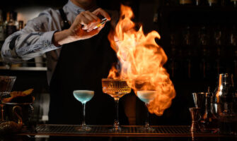 Bartender lighting drinks on fire