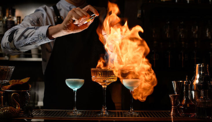 Bartender lighting drinks on fire