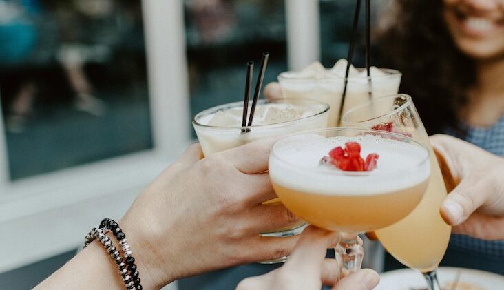 hands holding cocktails in a toast