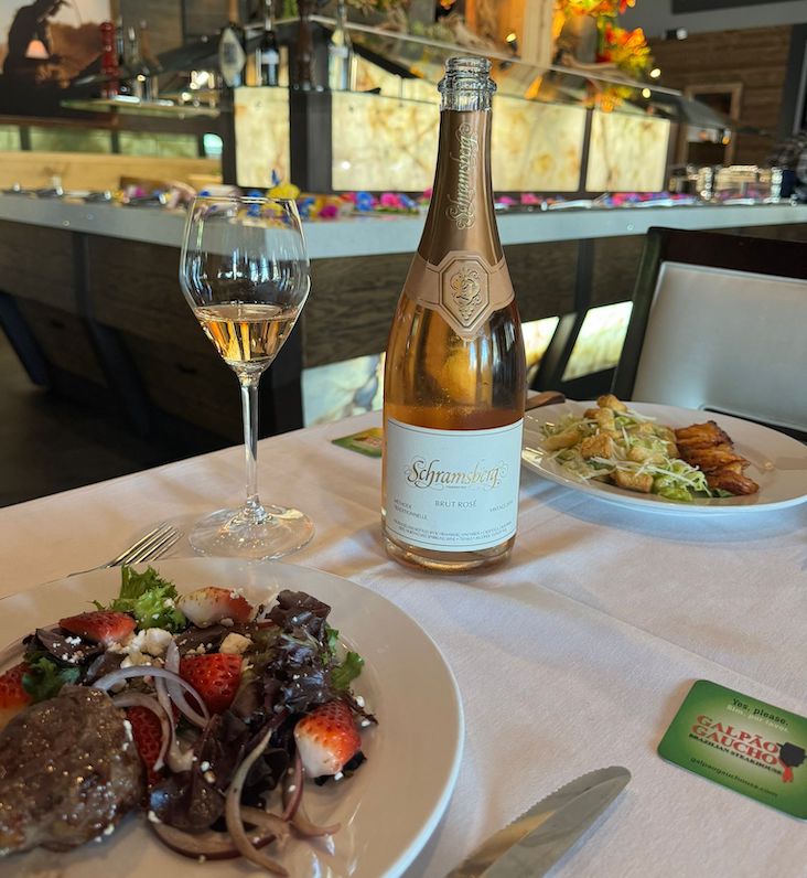 sparkling rose on a table with a salad