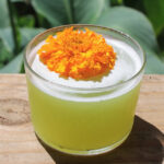 The green Mary Jane cocktail with an orange flower garnish