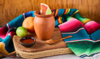 Refreshing cantaritos with tequila and lime, cocktail from mexico in a mug clay